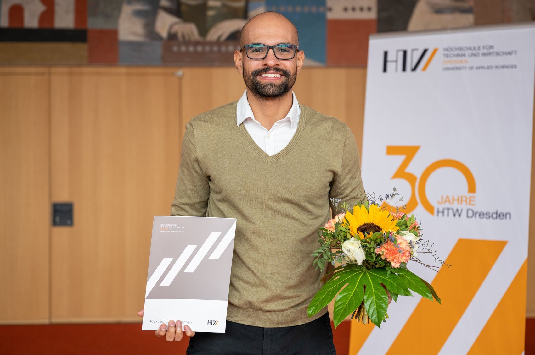 [Translate to English:] DAAD Preisträger Santiago Cordoba Cleves mit Blumen und Urkunde