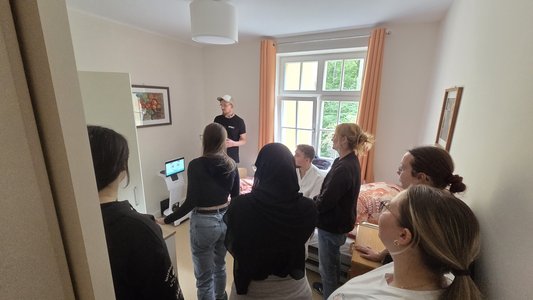 Mattias Klingner beim Präsentieren der Assistenzsysteme im Patientenzimmer vor den Pflegekräften