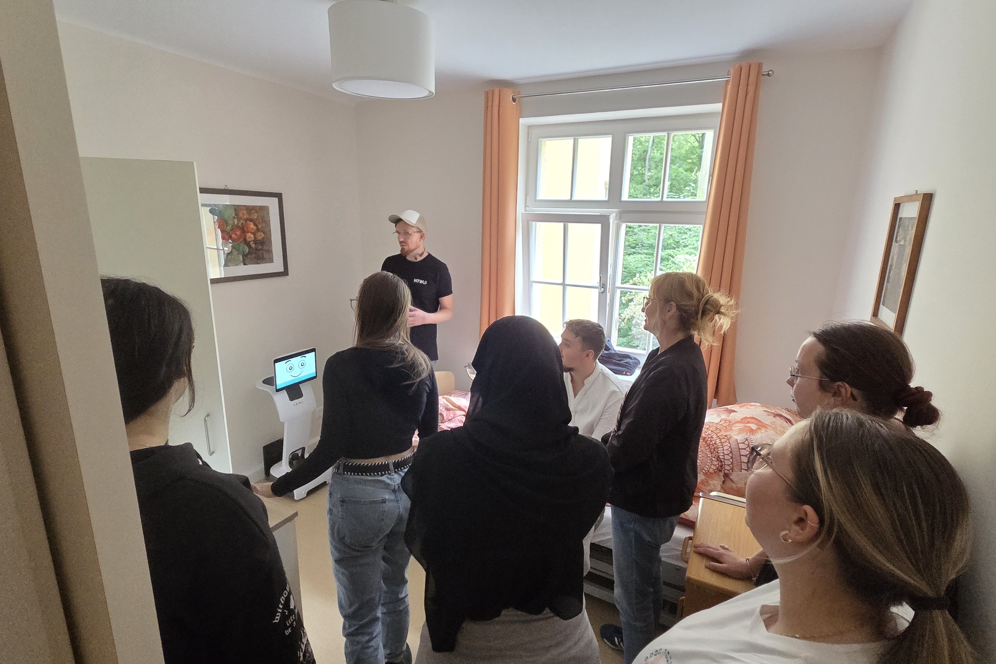 Mattias Klingner beim Präsentieren der Assistenzsysteme im Patientenzimmer vor den Pflegekräften