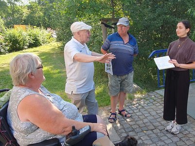 Junge Frau im Gespräch mit älteren Menschen