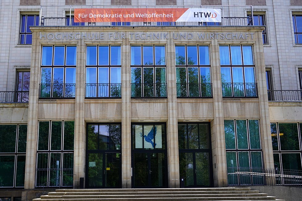 [Translate to English:] Bild des Hauptportals der HTWD mit dem Banner "Für Demoktratie und Weltoffenheit"