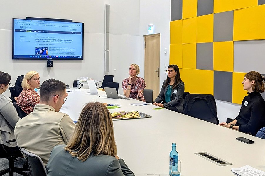 Frauen und Männer sitzen an einem Tisch