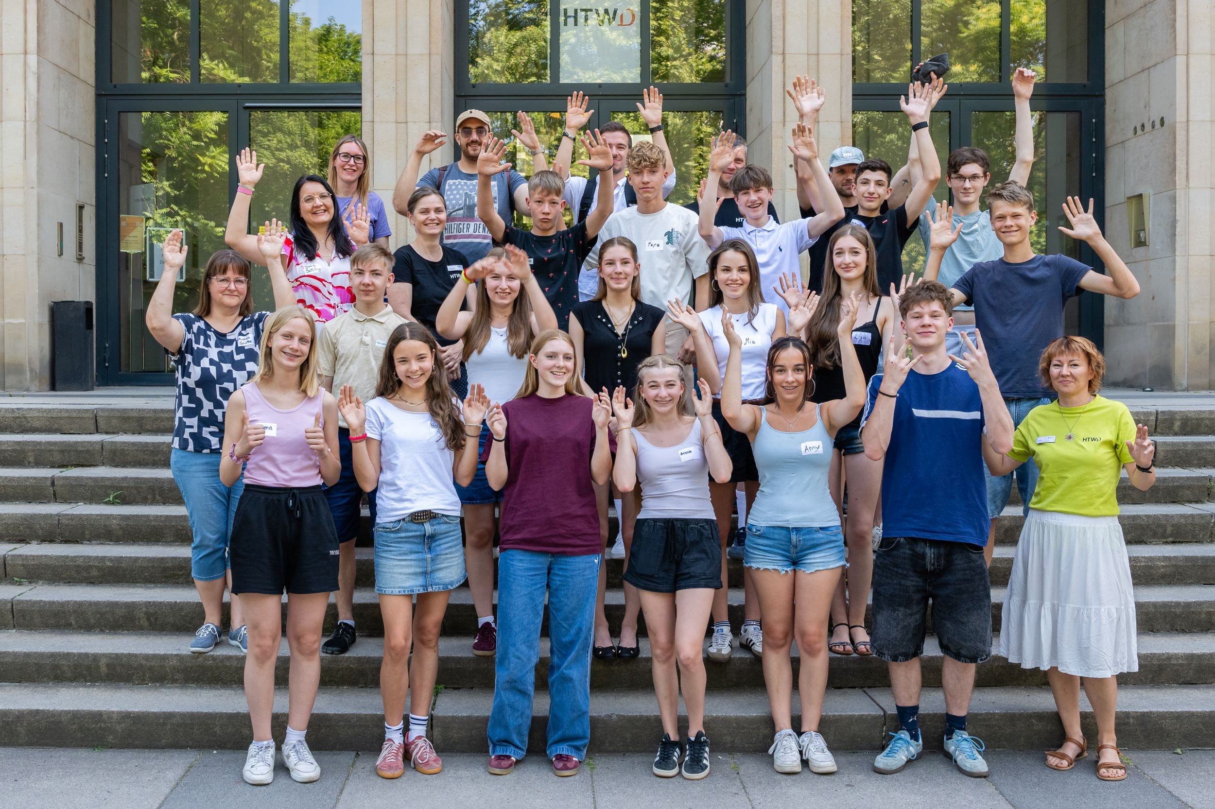 Menschen der Gruppe auf der Treppe vor dem Haupteingang der HTW
