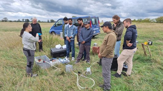 Frau erklärt auf einer Wiese Grundwasserprobennahme