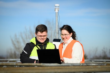 Ludwig Jacobs und Carolin Fischer überprüfen einen Windmesser auf einer Dachfläche