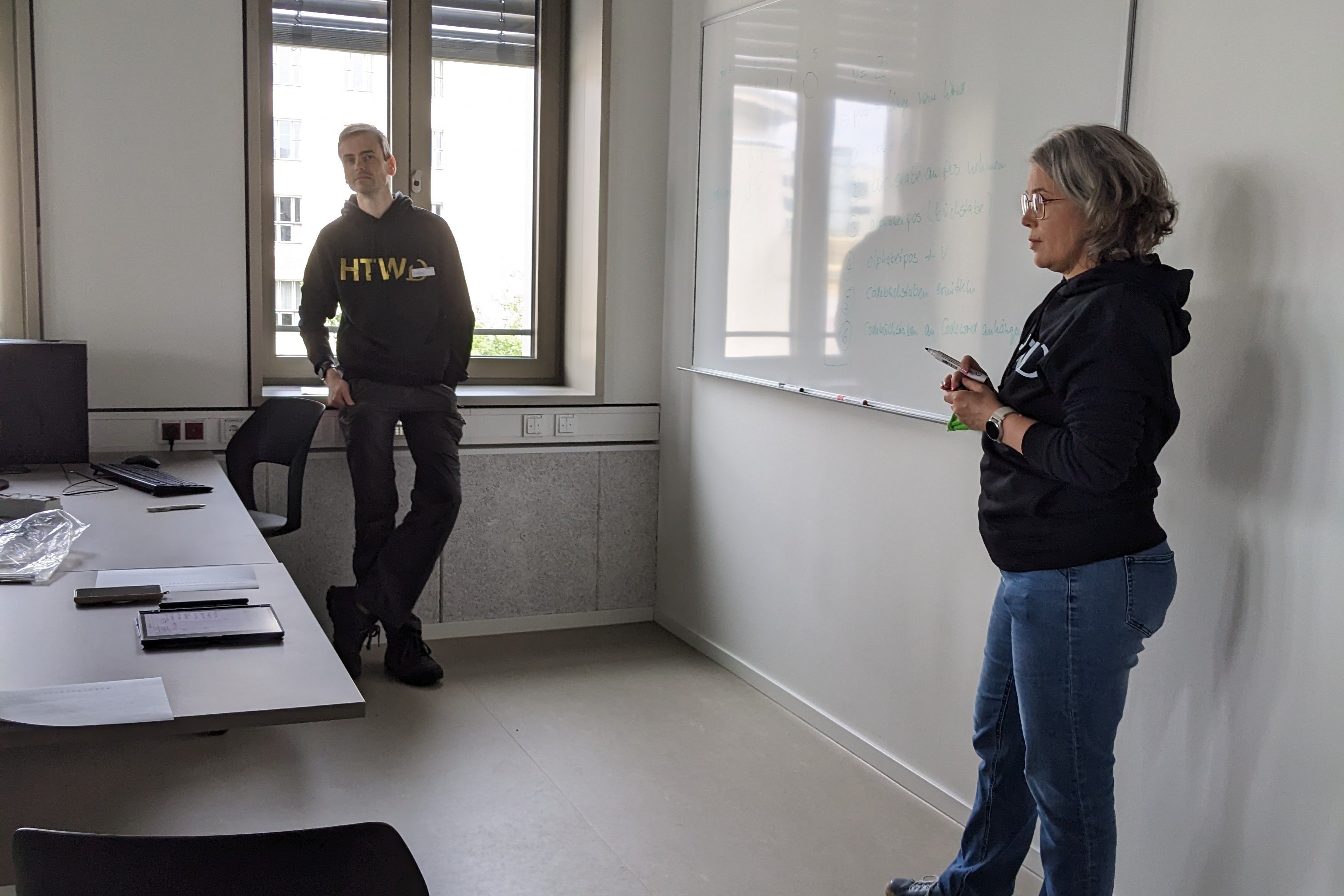 Mitarbeiter beim Erklären vor dem Whiteboard, Blick von der Seite