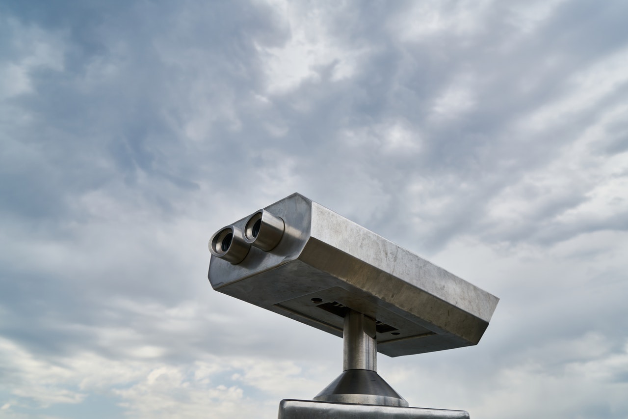 [Translate to English:] Fernglas vor blauem Himmel mit Wolken